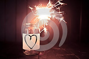 Hope for love, still life with heart jar and burning sparkler