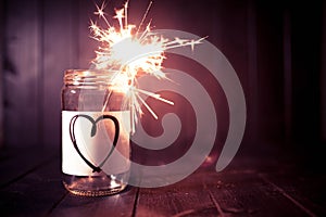 Hope for love, still life with heart jar and burning sparkler