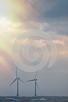 Hope. Motivational image of light breaking through over wind turbines