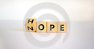 Hope or nope symbol. Male hand turns cubes and changes the word `nope` to `hope` on a beautiful white background. Business and