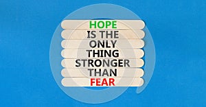 Hope stronger than fear symbol. Concept words Hope is the only thing stronger than fear on wooden stick on beautiful blue table