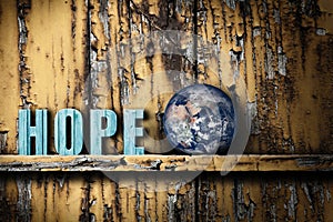 Hope text word and planet Earth on worn wooden background