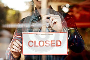 Hope to see you tomorrow again. Closeup shot of an unrecognizable man hanging up an open sign in a shop window.