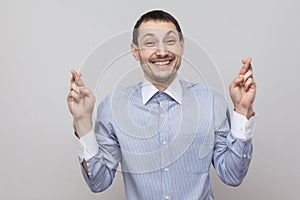 Hope to win. Portrait of funny handsome bristle businessman in classic blue shirt standing and looking at camera with hopeful eyes