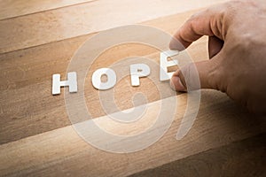 HOPE word with male hand on wood table.Business marketing,analysis