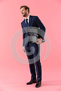 Hopeful businessman holding a briefcase and looking away