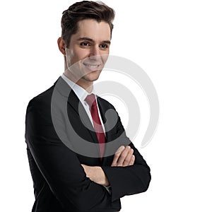 Hopeful businessman holding his arms crossed and wondering