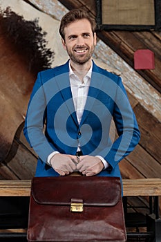 Hopeful businessman smiling and holding his briefcase