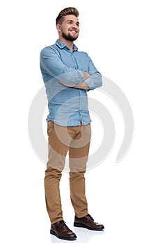 Hopeful casual man looking away with his hands crossed