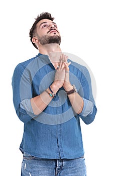 Hopeful casual man looking upwards and praying