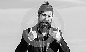 Hopeful and confident about future. Thumbs up gesture. Man bearded optimistic businessman wear formal suit sky