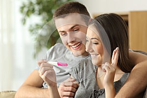 Hopeful couple checking a pregnancy test photo