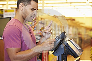 Hopeful Customer Paying For Shopping At Checkout With Card Cross