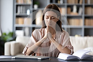 Hopeful employee sitting at table with folded hands.