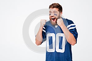 Hopeful excited man fan in blue t-shirt standing isolated