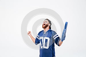 Hopeful excited man fan in blue t-shirt standing isolated