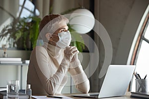 Hopeful female employee in protective gear praying