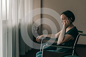 Hopeful female person with disability talking on mobile phone