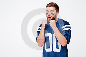 Hopeful male fan in blue t-shirt standing isolated