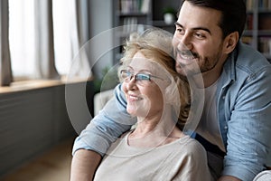Hopeful mature mother and adult son visualizing at home