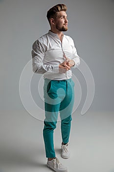 Hopeful young man posing and playing with his hands