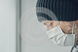 Hopeless Covid-19 patient with protective face mask in self-isolation