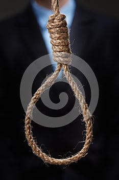 Hopeless depressed young man, is about to hang himself on noose.