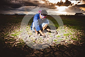 Hopeless and lonely Farmer sitiing on dry ground and finding Living plants. Global warming crisis