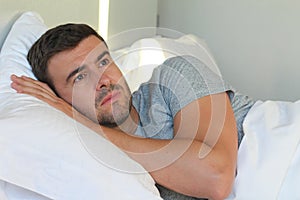 Hopeless man lying down in bed