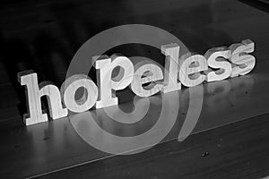 Hopeless, text words typography written with wooden letter on black background, life and business negativity