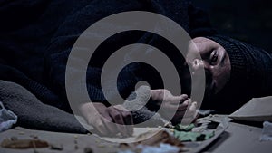 Hopeless vagabond lying on floor full of garbage, poverty, social insecurity