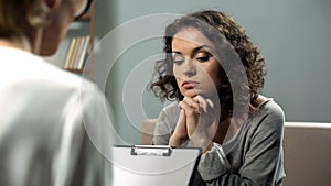Hopeless young lady listening to psychologist attending personal therapy session