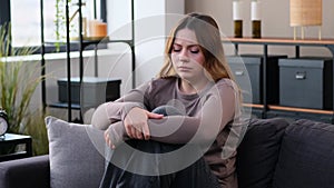 Hopelessness Woman In Depression Sitting On Sofa At Home