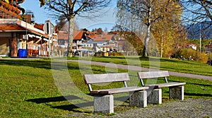 Hopfensee,Bavaria, GERMANY , November 07, 2020.Empty wooden bench on the promenade of Lake Hopfensee on a sunny day , Allg u,