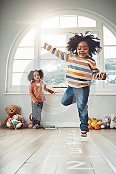 Hopscotch, games and children play in home having fun, enjoy entertainment and relax together in room. Childhood, happy
