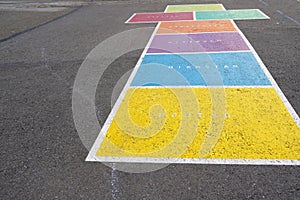 Hopscotch painted on the ground in various colors with weekdays in German language in a schoolyard in Switzerland