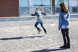 Hopscotch on the schoolyard with friends play together