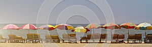 Horisontal banner - row of empty wooden parasol with colorful umbrellas
