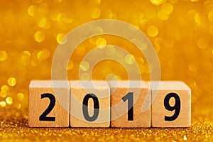 Horisontal numbers of 2019 on golden sparkling background.