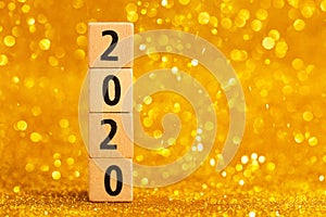 Horisontal numbers of 2020 on golden sparkling background.