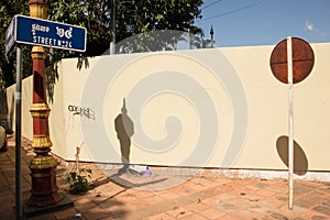 Horizontal abstract view of round sign on a pole on a sunny corner with streetsign visible