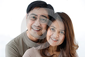 Horizontal back view portrait of senior Asian husband hugging his wife. A lovely couple standing closely and embracing each other