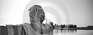 Horizontal banner or header with real scarecrow with fearful face in front of the lake - Halloween concept - Black and White
