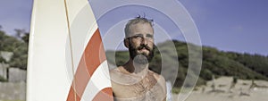 Horizontal banner or header with surfer holding his surfboard on the beach - Hipster man standing on the beach and waiting big