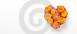 Horizontal banner. Orange rose flowers in heart shape bowl on white background. Valentines day concept. Flat lay, top