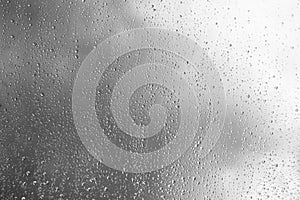 Horizontal black and white window glass with water drops background