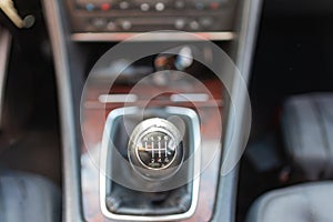 Horizontal close up high angle image of a black and white manual car gear stick