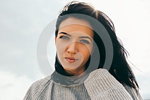 Horizontal close-up portrait of dreamy attractive young woman being playful and carefree with beautiful smile on sunny day.