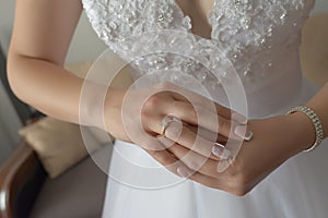 Horizontal close-up of young Caucasian female manicured hands fitting proudly her diamond engagement ring on her right hand
