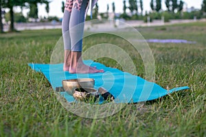 Horizontal closeup photo of slim female legs on yoga mat